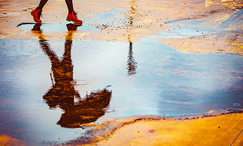 Reflection of persons feet in a puddle