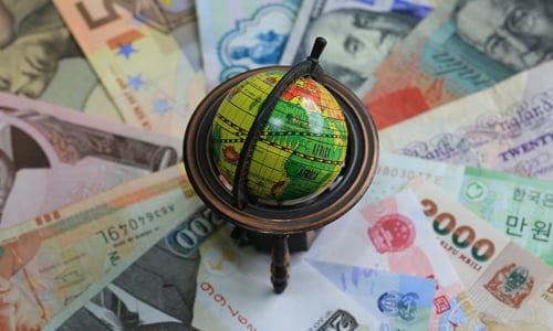 A globe on top of banknotes from different countries