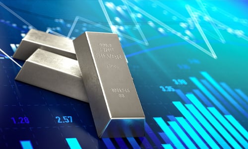 Silver bars with a background of commodity market charts